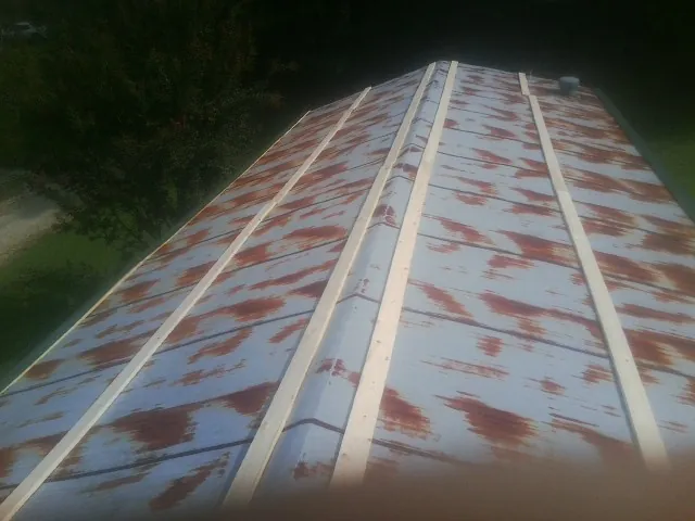 Rusted metal roof panels with new wood purlins before replacement — Storm Damage Roof Repair in Kenmore by Roofing Brothers